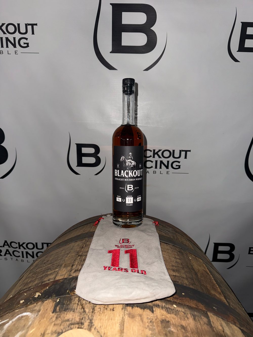 The 11 year old, 96 proof bottle with its bag on a barrel