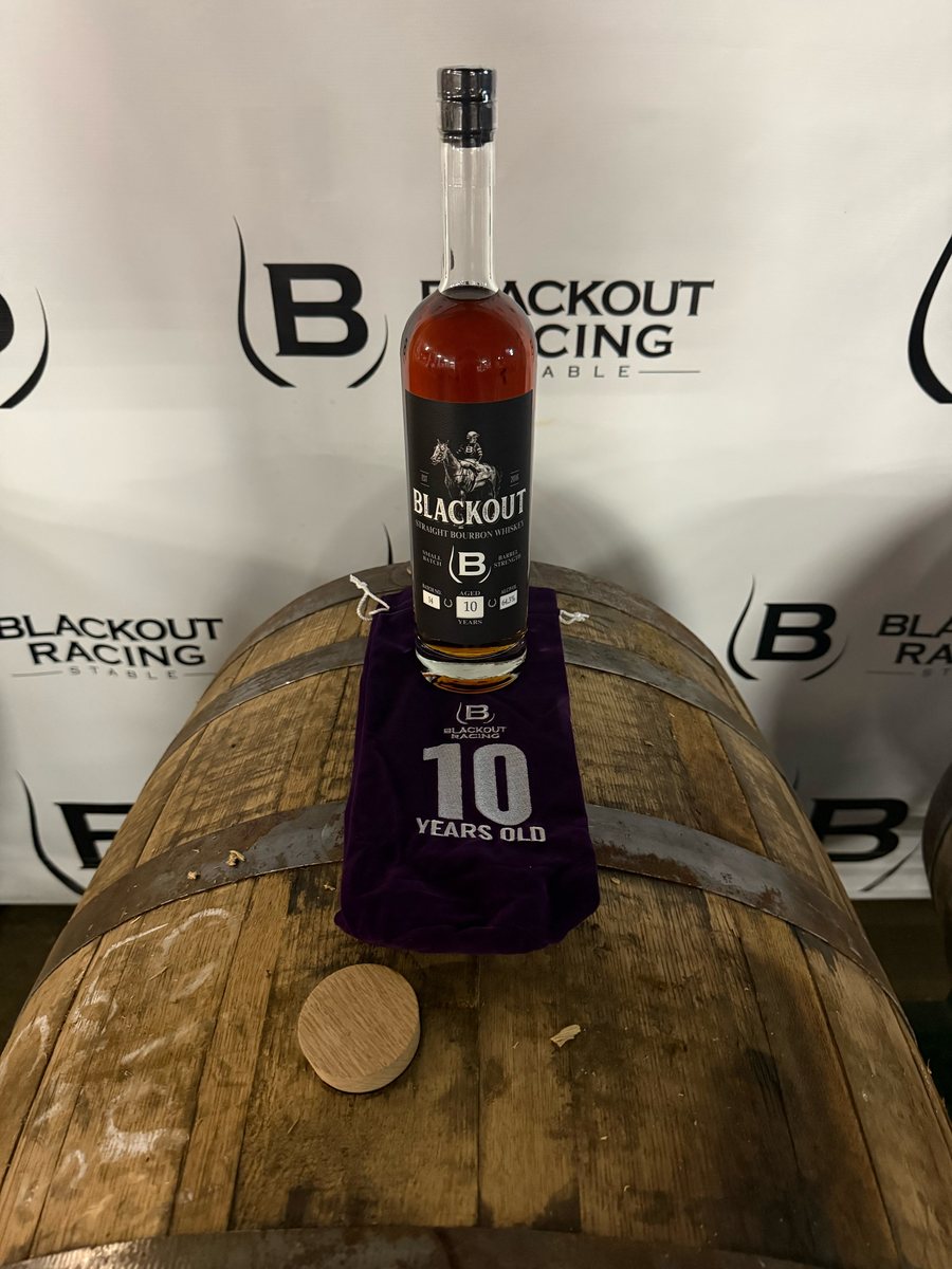 A 10 year old bottle on a purple bag on a barrel