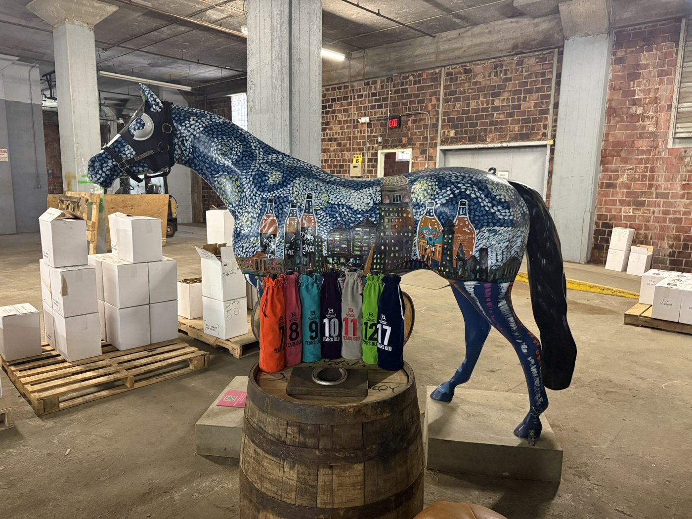 A painted horse statue behind Blackout bags numbered by age on a barrel