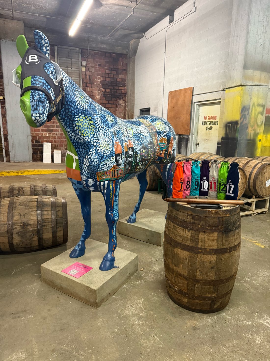 A painted horse statue next to Blackout bags numbered by age on a barrel